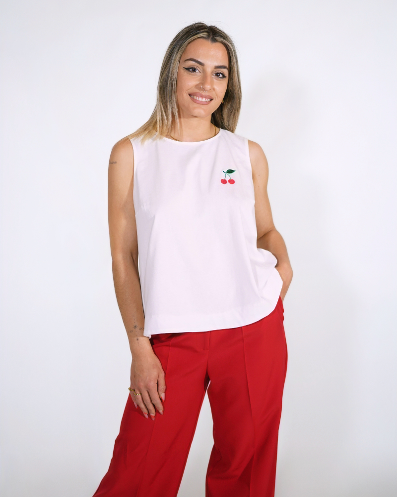 Κοντινή όψη του Cherry Top: Λευκή αμάνικη μπλούζα από 100% βαμβάκι με κεντημένα κεράσια στο στήθος.
