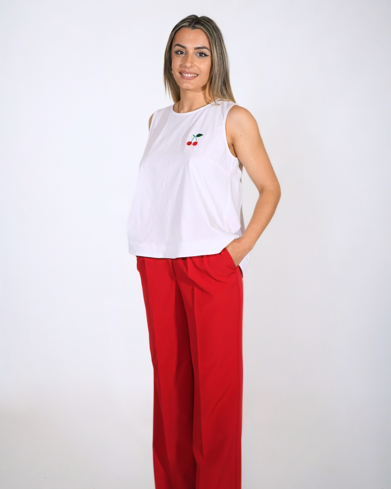 Πλήρες καλοκαιρινό look με το βαμβακερό Cherry Top και ψηλόμεση κόκκινη παντελόνα σε λευκό φόντο.